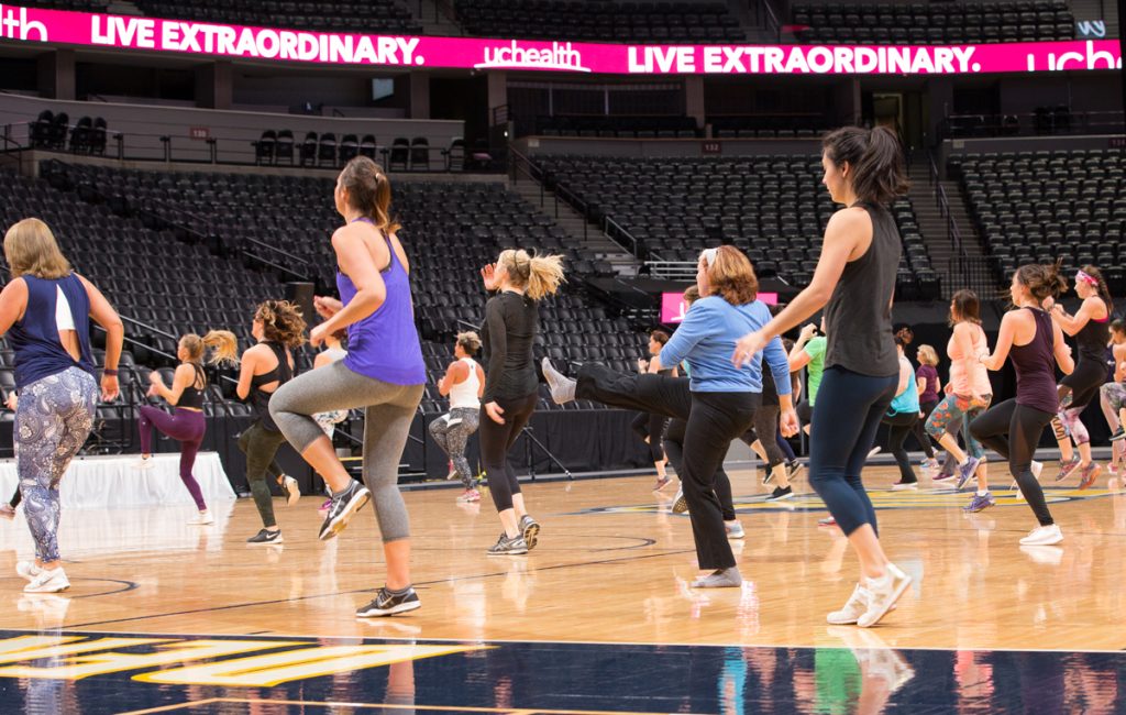 women taking a class on the floor of the Nuggets' arena.