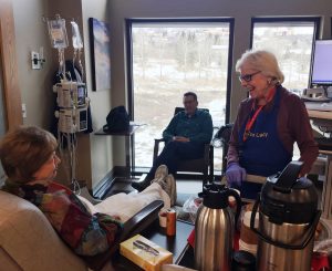 Joan Gibbs, known as "The Cookie Lady," is shown distributing cookies to a patient at the UCHealth Jan Bishop Cancer Center in this photo.