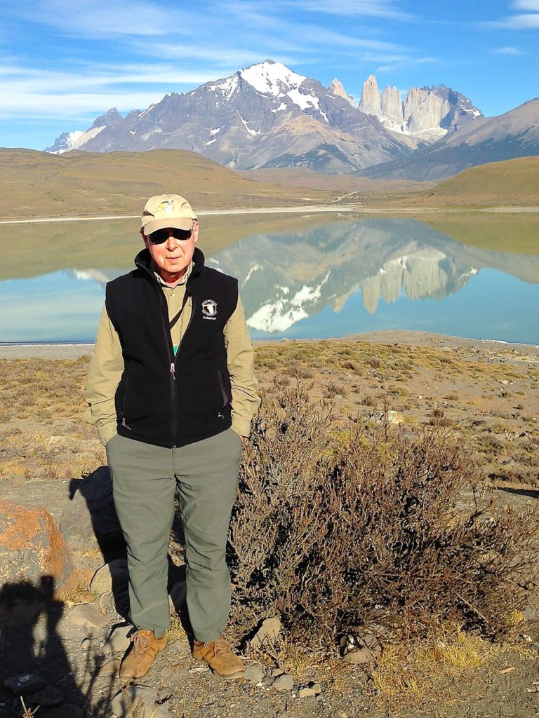 In this photo, Mike Bloom stands in front of a lake in Patagonia where he and his wife, Mike, went to go birding in 2015.