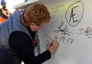 Marilyn Schock, president of UCHealth Greeley Hospital, signs a message on a beam in this photo. The beam was raised and installed in one of the highest points of the hospital building.