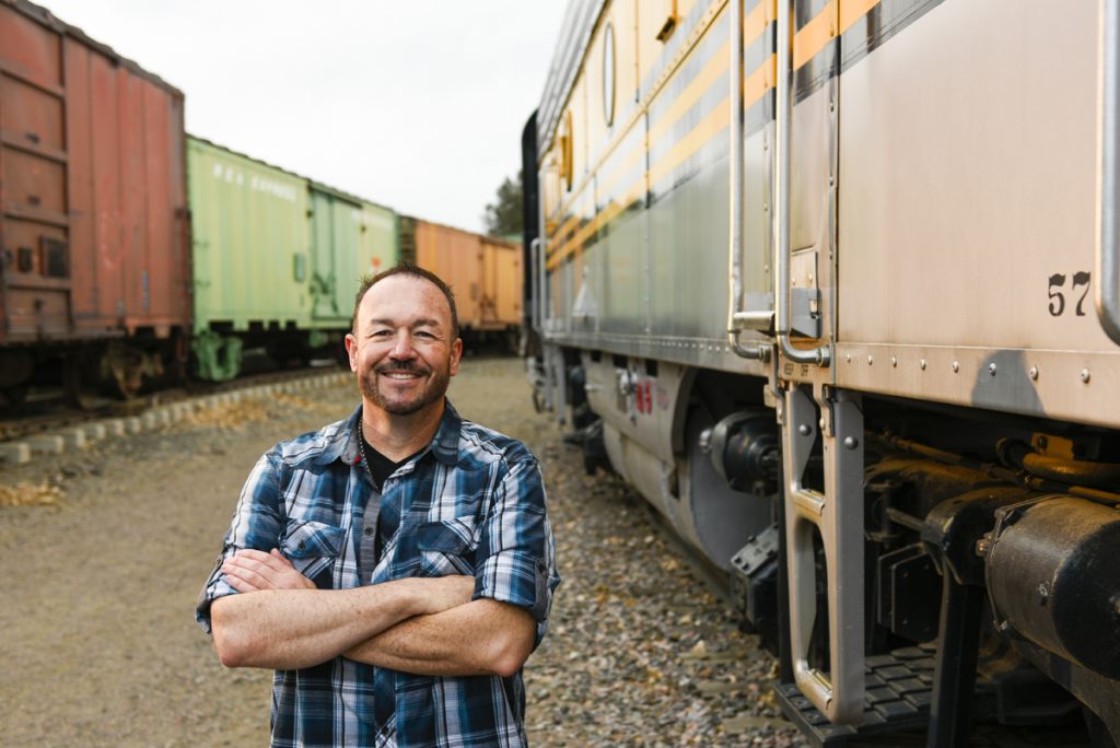 Stephen Mullen poses with some colorful train cars at the Colorado Railroad Museum. He was diagnosed with a brain tumor that threatened his hearing.