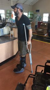 Jordan Leigh walks in two boots with crutches on the first day out of his wheelchair after rupturing two Achilles tendons.