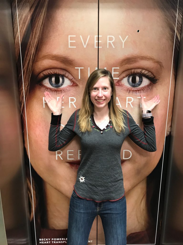 Becky Pomerleau poses with an ad that shows her face