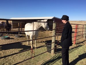 Marcy Brossman visits with one of the family's horses on their property in Cheyenne Wells, Colorado.