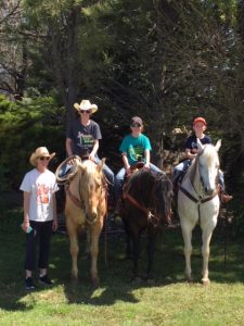 Marcy Brossman and her children on an outing with their horses.