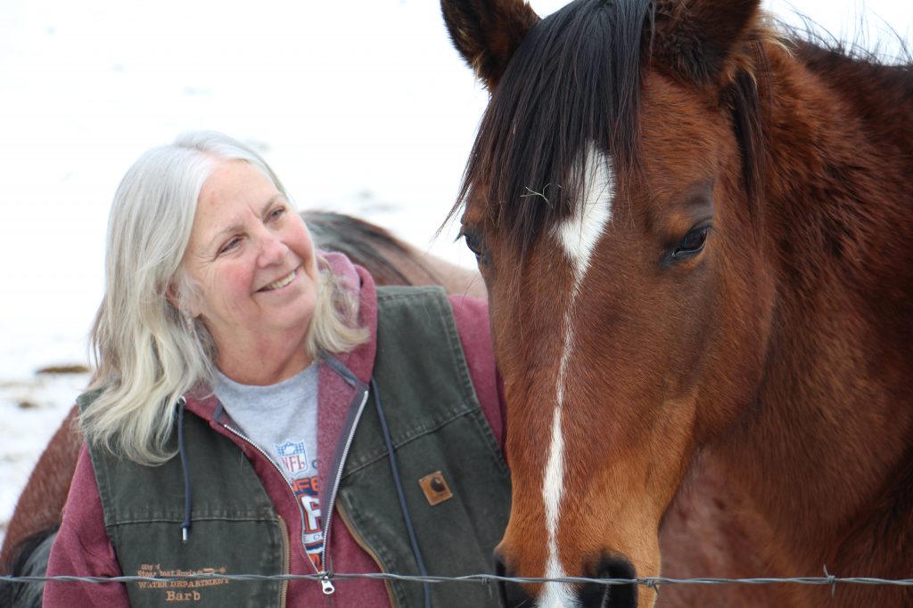 Barb Wheeler looks fondly at Delaney, one of her horses.