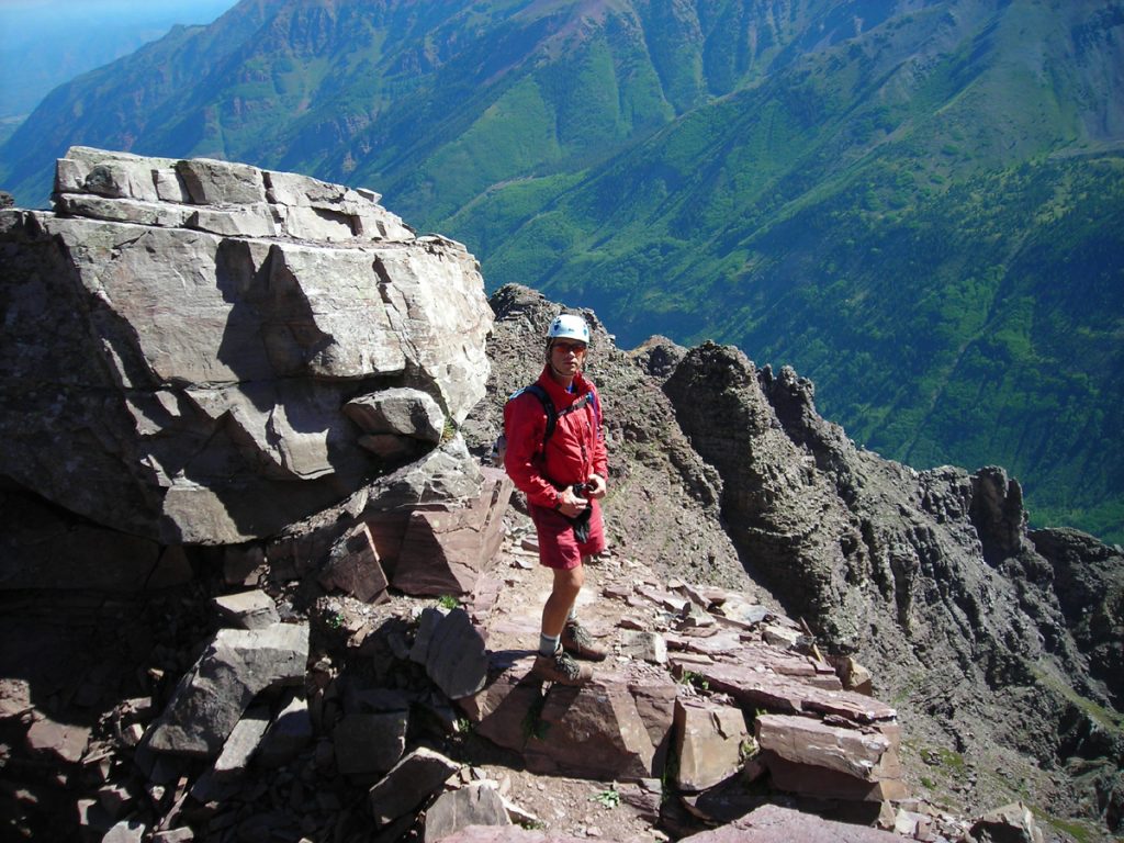 Patrick Gaines poses on a rocky outcropping on a Colorado peak. He has used alternatives to opioids and exercise in dealing with chronic pain.