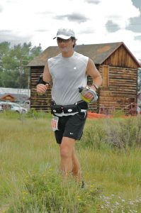 Patrick runs and uses alternatives to opioids to cope with chronic pain. Here, he is running in the mountains with a barn behind him.