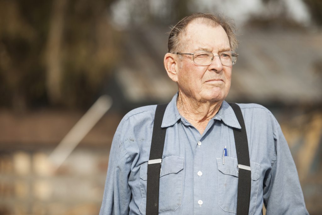 Portrait of an elderly man on his farm, looking off into distance