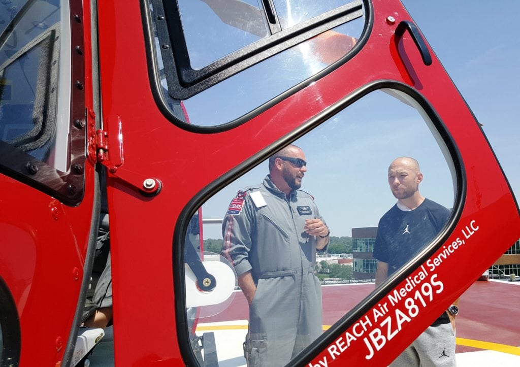 UCHealth Flight Paramedic Matthew Bergland talks to Eddie Kerr near the UCHealth Lifeline helicopter.