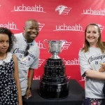 A cancer survivor and his family poses with the Kelly Cup championship trophy.