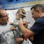 A Colorado Eagles coach autographs a fan’s shirt at a special locker room celebration for UCHealth cancer survivors.