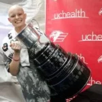 A cancer survivor poses with the Kelly Cup championship trophy.
