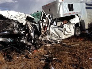 A white pick-up truck is completely destroyed. Behind it is a horse trailer that's off kilter. Archie Chant was pinned inside. He survived and now is riding, roping and ranching again.