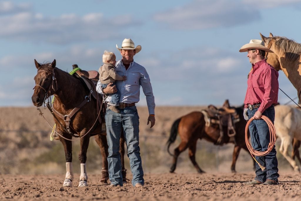 Archie Chant holds his son, Hudson. Next to him is his doctor, Jason Stoneback. Their horses are behind them.