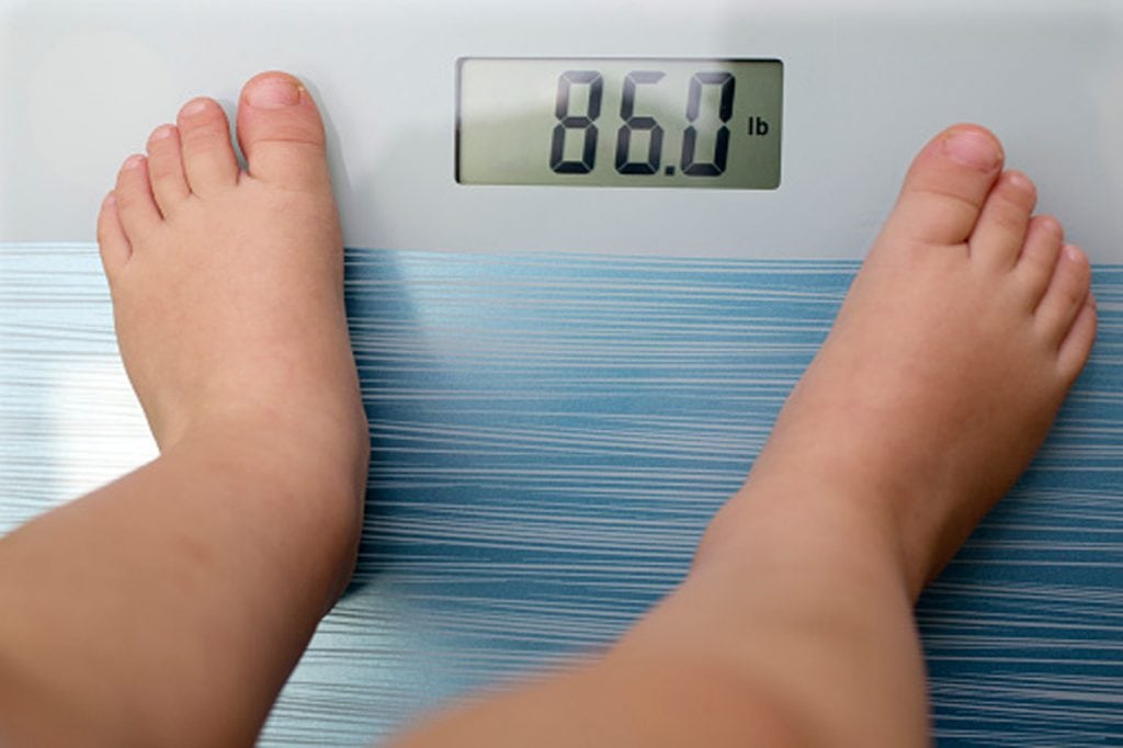 an overweight child steps on scale