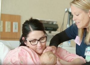 A nurse reaches in to help a new mom as she breastfeeds her baby. UCHealth now has more Baby-Friendly hospitals.