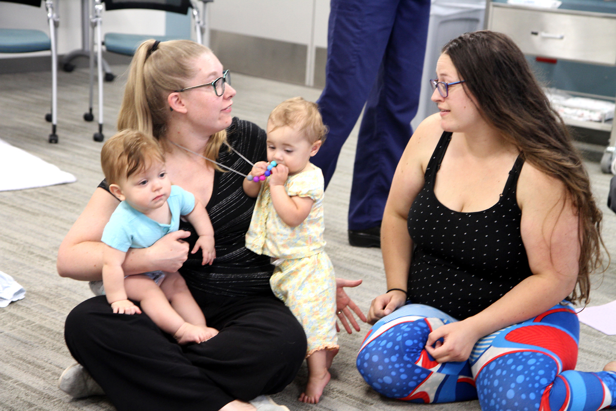 nursing mom talks to another mom at breastfeeding support group.