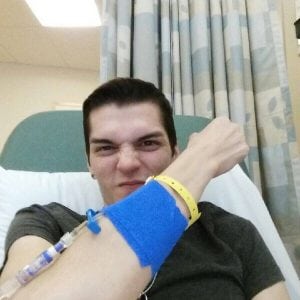 Stephen Estrada holds up his arm defiantly during his first immunotherapy treatment.
