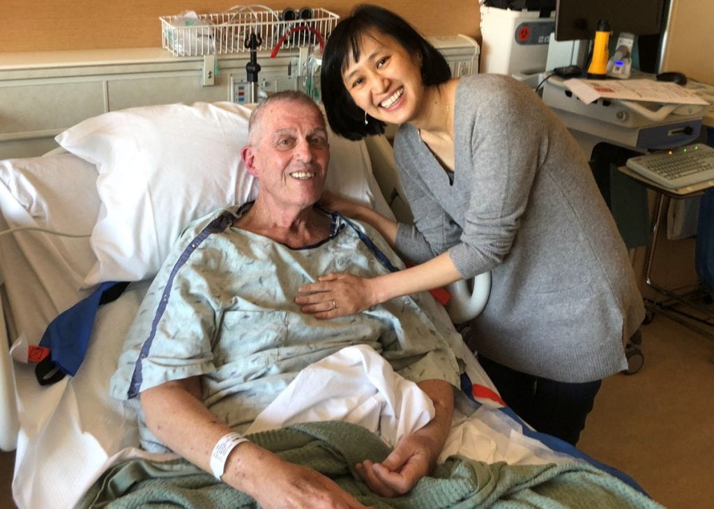 Bill Brennan in his hospital bed with his doctor, Enkhsetseg Purev, who helped him with CAR-T immunotherapy for deadly blood cancer.