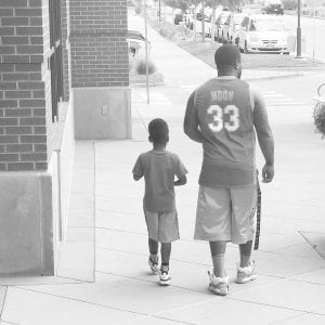 Photo of David Kenyatta and his son, who is 5. You see the two of them from behind.