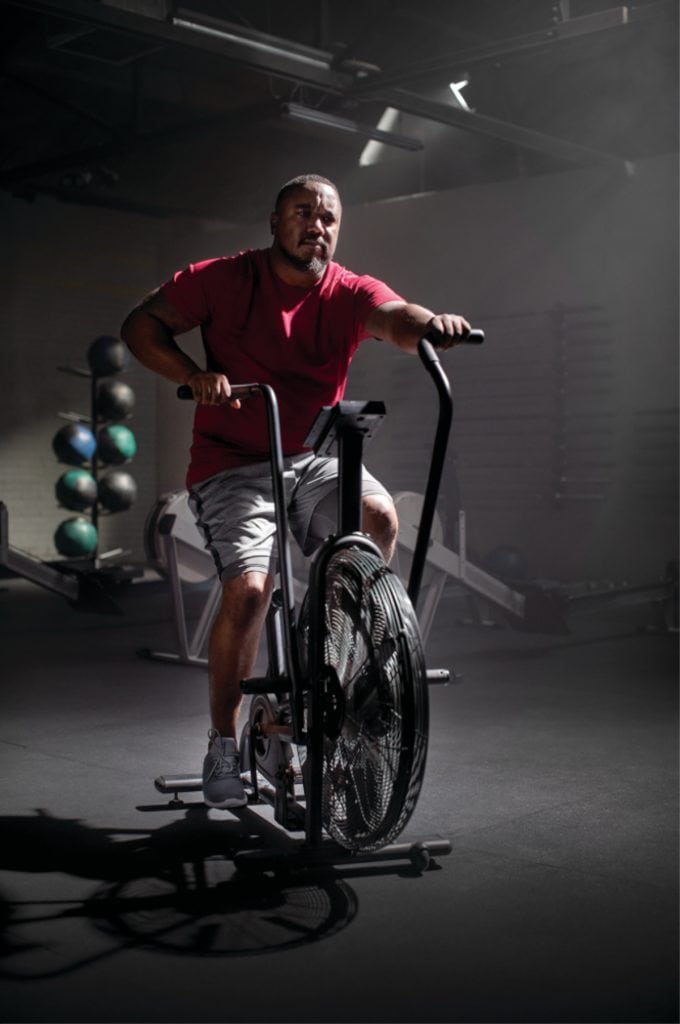 David Kenyatta riding an exercise bike after recovering from a stroke.