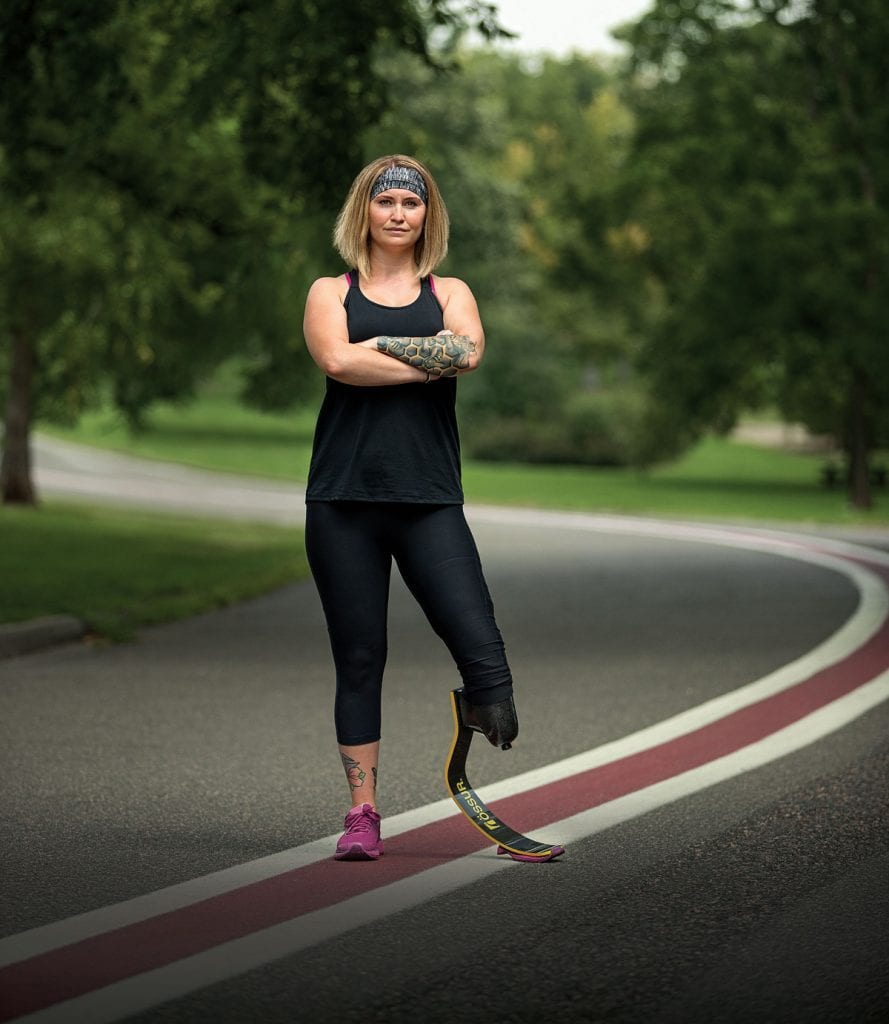 Alina Miller had to jump four stories out of her burning apartment building. Now, she's embracing every adventure that comes her way. She poses here with a road. Alina had to have one leg amputated and runs with a blade.