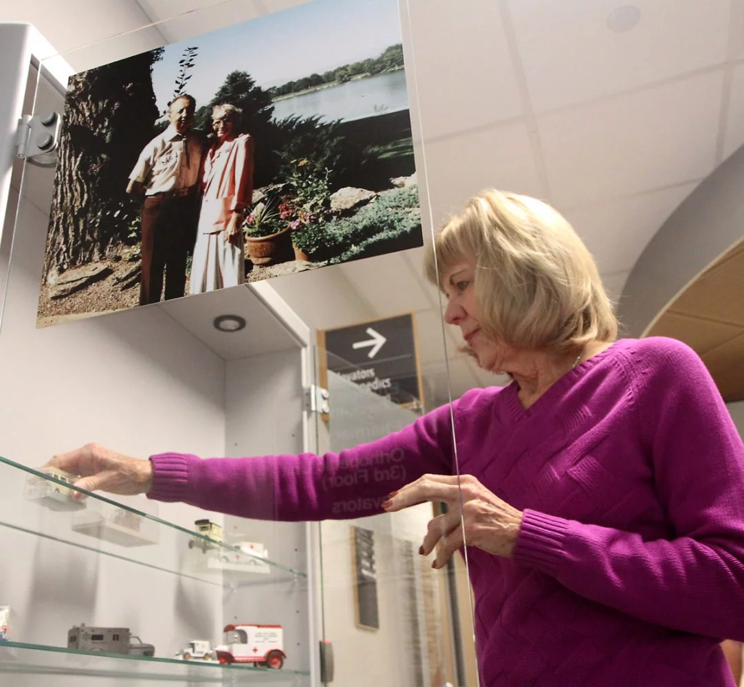 Kathy puts a mini toy ambulance on the shelf