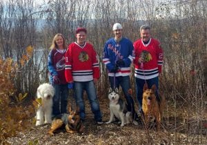 family with hockey jerseys and four dogs