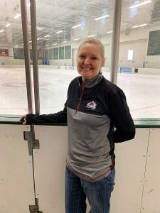 Mary standing in front of a hockey rink