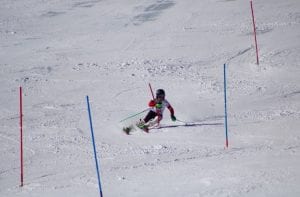 Emi Cooper skis around race poles.