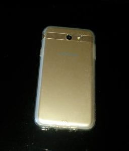 gold phone laying on a black background.