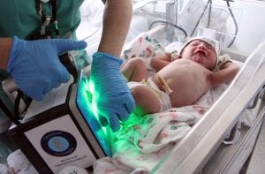 baby footprints being scanned with hand-held machine