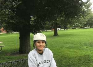 Jasmine Porr, wearing a helmet, is seated in a park.
