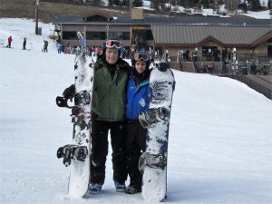 Bob Hunt and his son stand in the snow as they hold their boards.