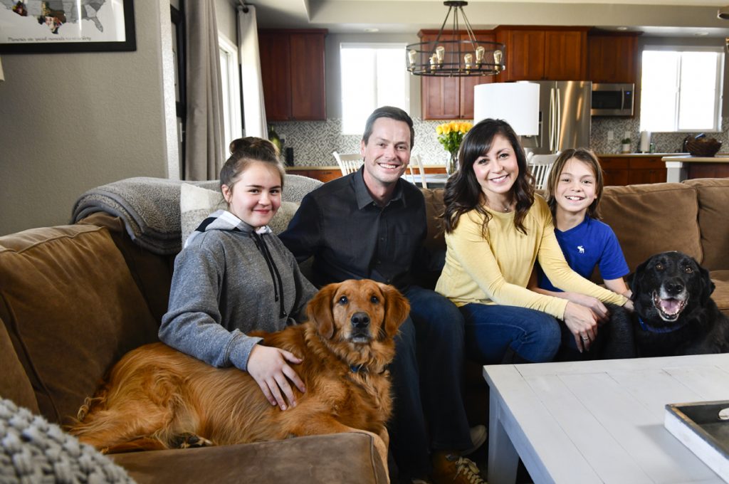 Faith Vigil, center, saved her family – and their two dogs – from carbon monoxide poisoning. Thanks to Vigil's quick thinking, everyone is healthy again. From left to right, daughter, Mila, 11, with Zeb, a golden retriever, Paul Schreder, Vigil, and Will, 14, with Jackson, a black lab. Photo by Cyrus McCrimmon for UCHealth.