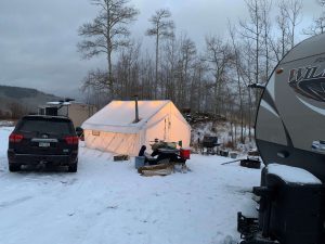 This photo shows a hunting camp with tents and mobile campers.
