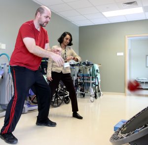 Dan tosses a back to himself via a trampoline while the therapist watches.