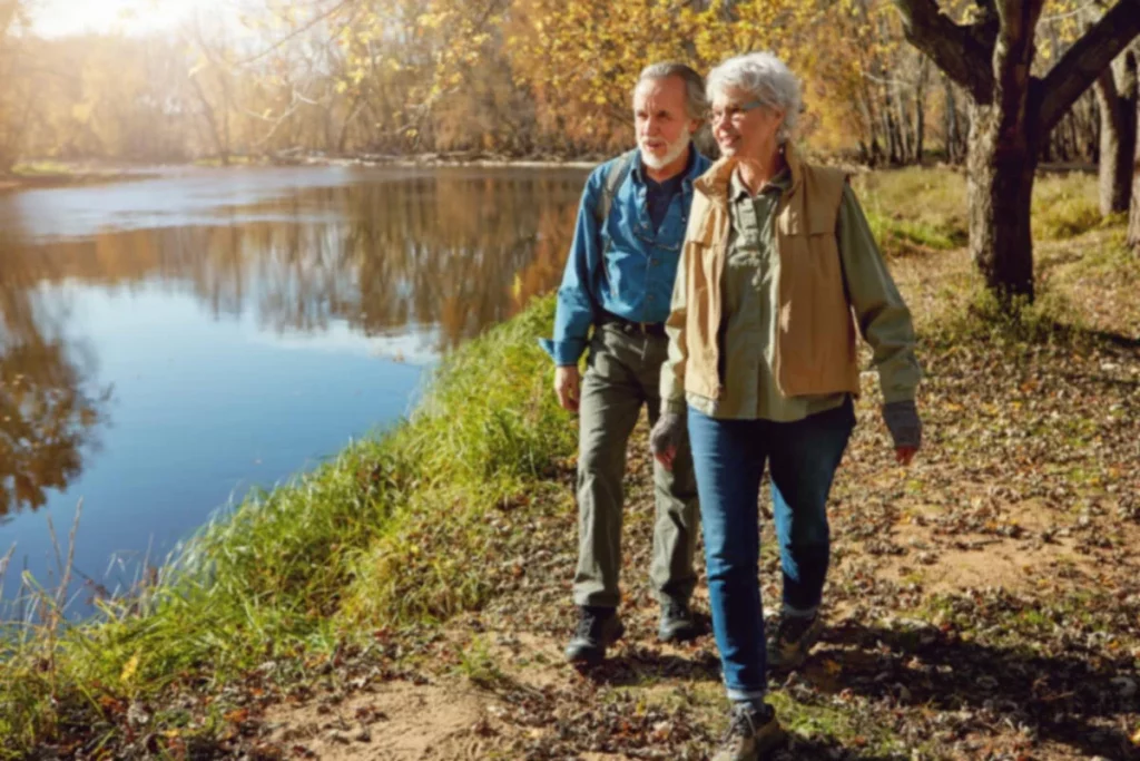 A senior couple goes for a hike along the water's edge.