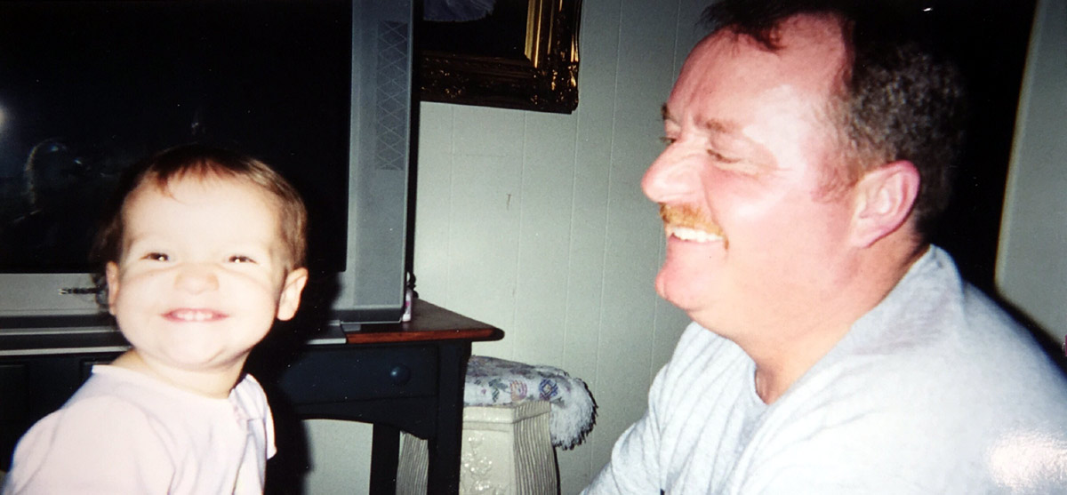 father smiling at his toddler daughter