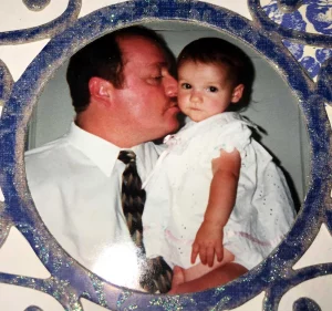 father kissing his toddler daughter