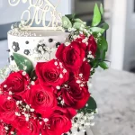 white and black cake with red roses
