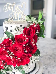 white and black cake with red roses