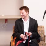 man in tux holds tie