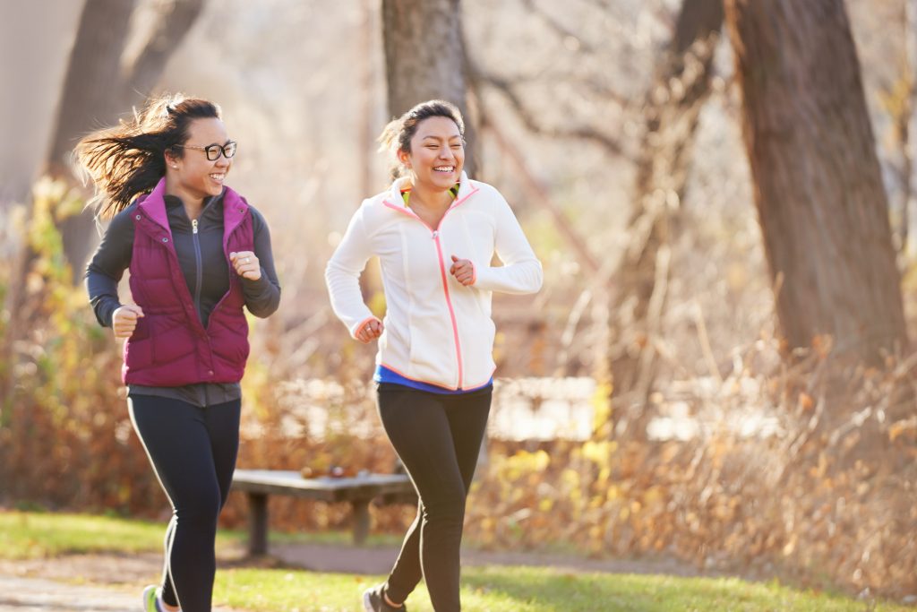 Two women jog in a park