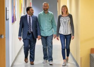 UCHealth cardiac surgeon Dr. Muhammad Aftab, left, with Brian and Kelsey McNeill. Aftab performed a 14-hour surgery to repair Brian’s badly infected aortic valve with aortic root infection.