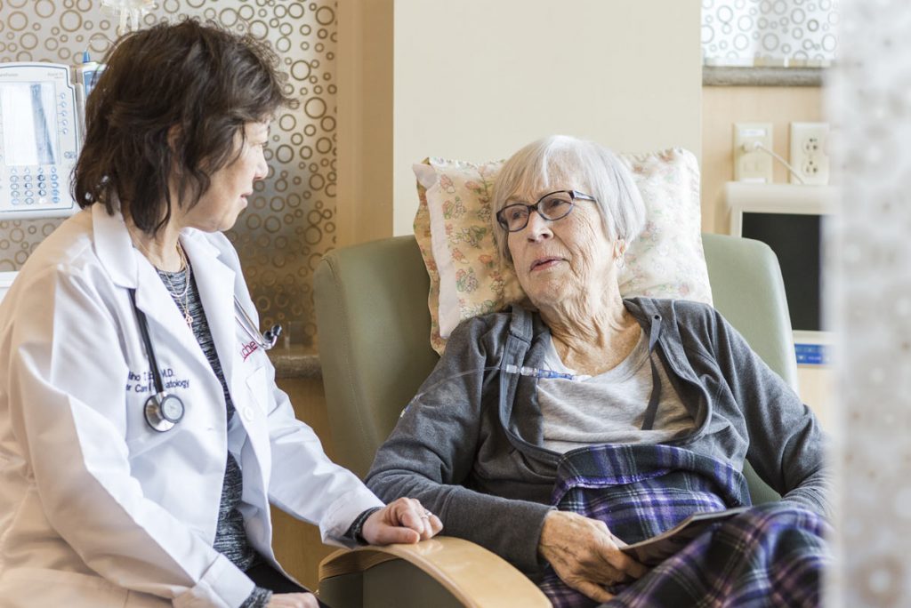 A photo of a doctor speaking to a cancer patient