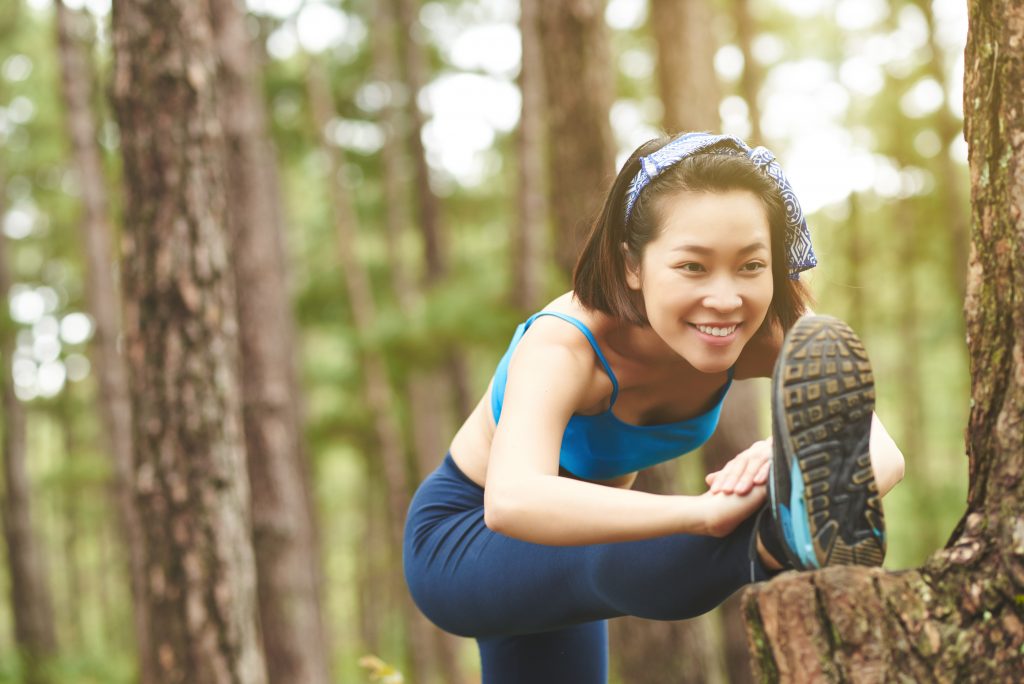 A woman stretches outdoors before an activity.