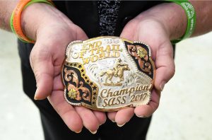 Kidney transplant recipient Sara Millard holds her rodeo belt buckle.