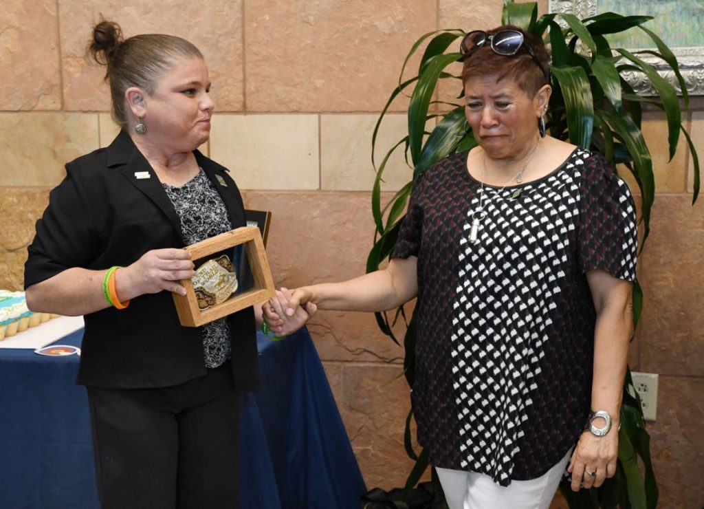 A kidney transplant recipient gives her donor's mother a rodeo belt buckle to honor the kidney donor.